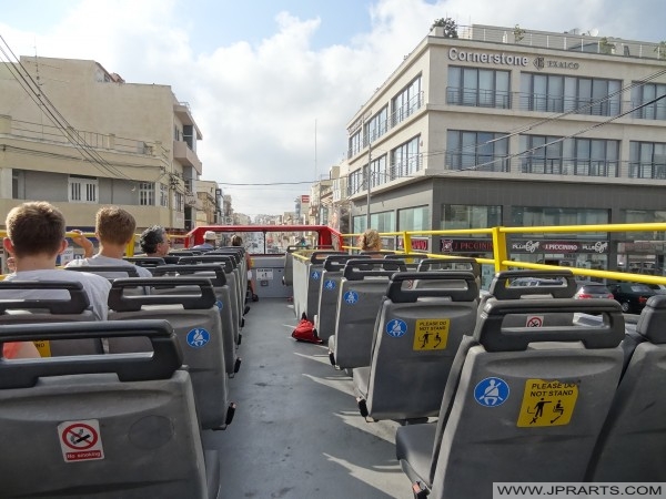 Hop on Hop off autobus projede budovu Cornerstone Business Centre v Mosta, Malta