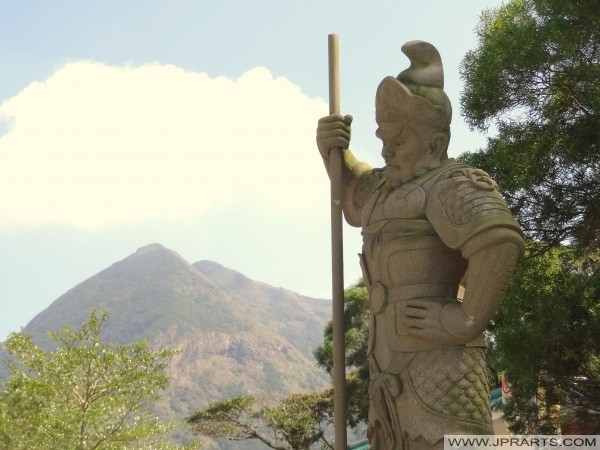 The General Sandira (珊底羅) Represents 11 AM -1 PM and the Horse of the Zodiac. He is armed with a Conch Shell (Ngong Ping, Hong Kong) Der General Sandira (珊 底 羅) Stellt 11.00 -1 Uhr und das Pferd des Tierkreises. Er ist mit einer Muschelschale (Ngong Ping, Hongkong) bewaffnet